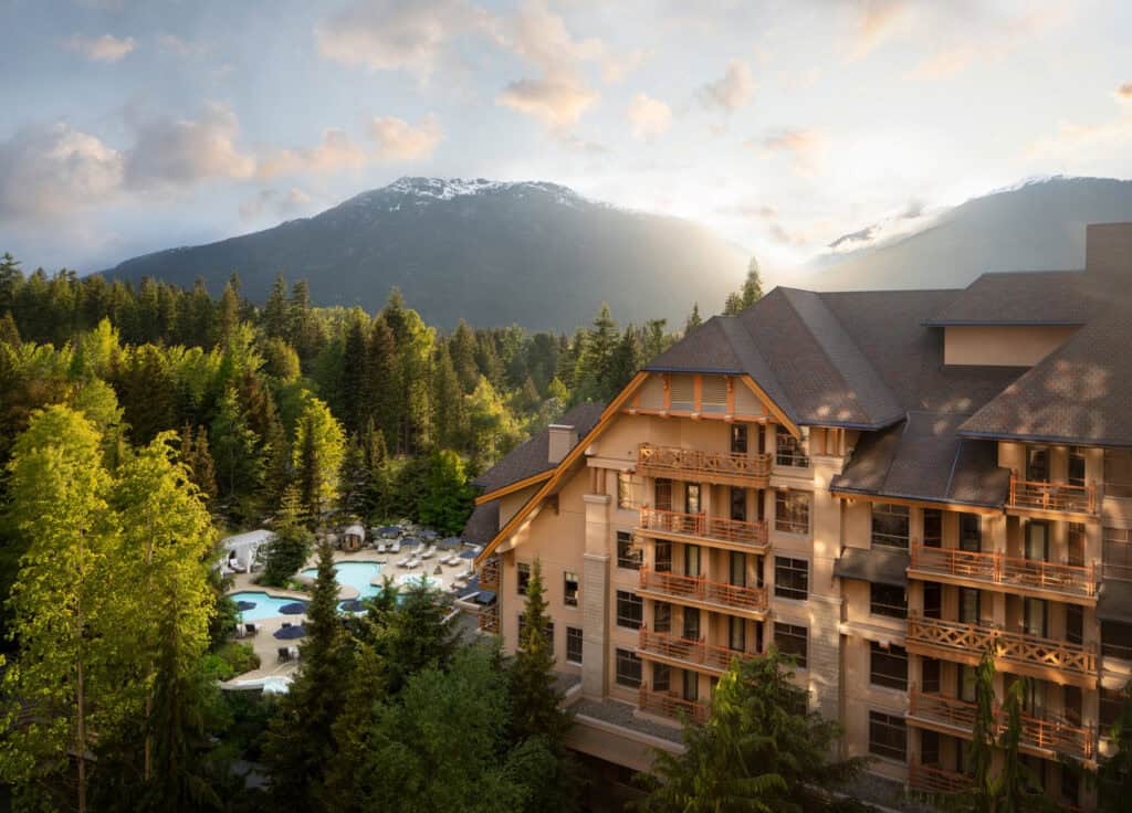 The spectacular exterior of the Four Seasons Hotel, Whistler, BC, along with its outside pools.  The mountains rise up in the background.