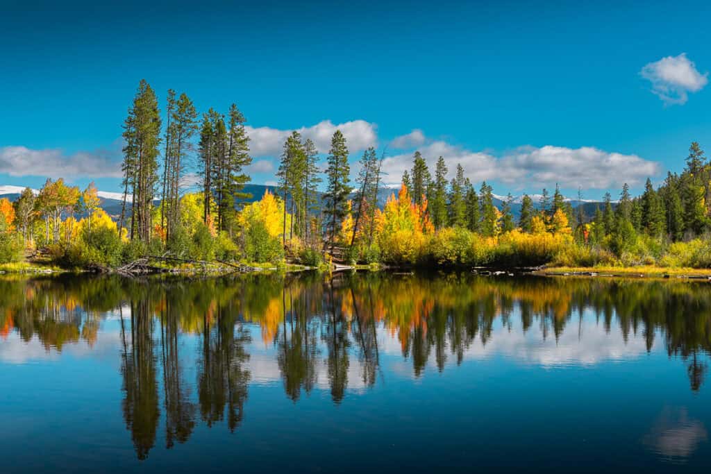 Colorful trees surrounding Rainbow Lake and reflecting in the water.