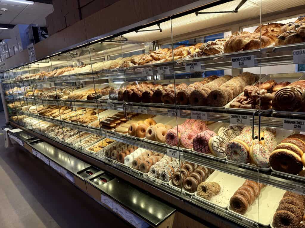 A vast display case with croissants, cookies, brownies, donuts, turnovers, muffins, and more.