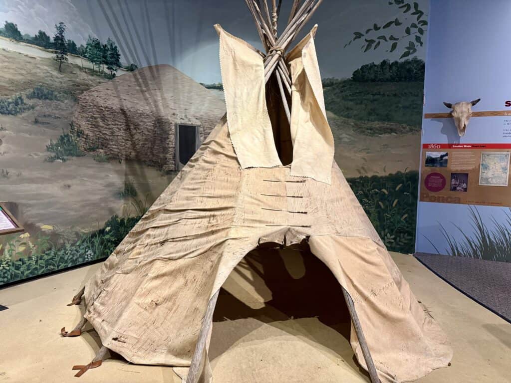 A rawhide teepee with an open flap so visitors can enter.
