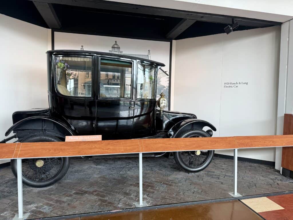 A black 1920 car with tall windows and a roomy interior.