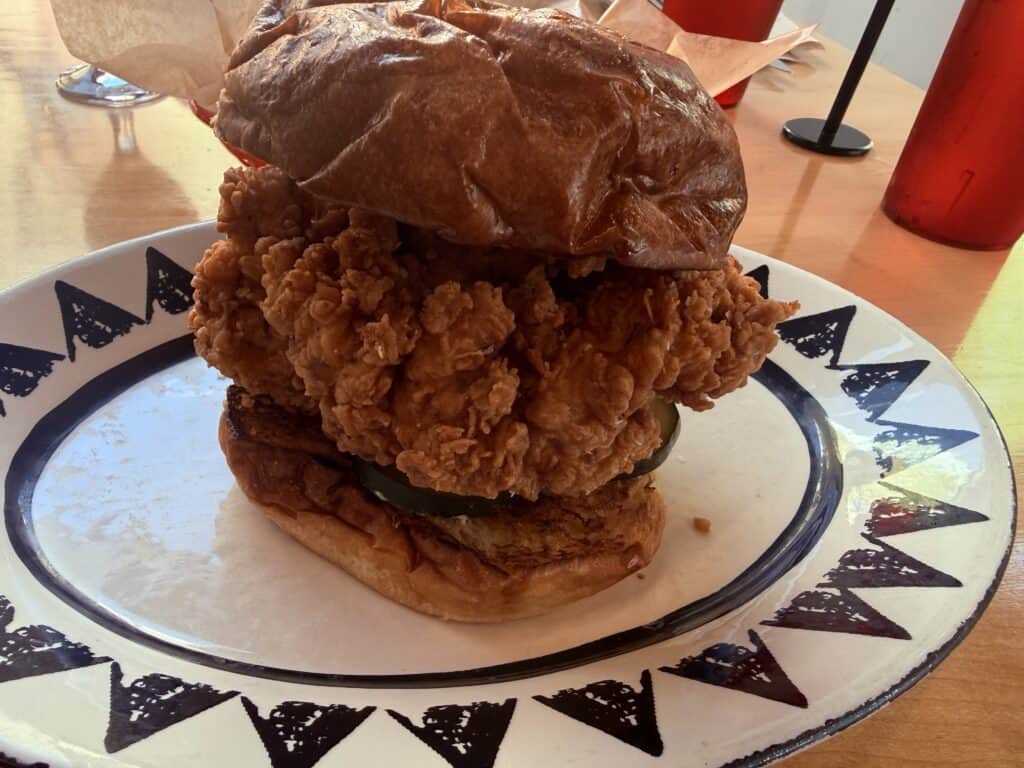 A giant piece of fried chicken on a bun.  Almost as tall as it is wide.