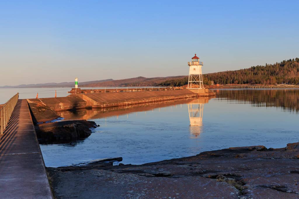 Grand Marais lighthouse at the edge of a breakwater wall.