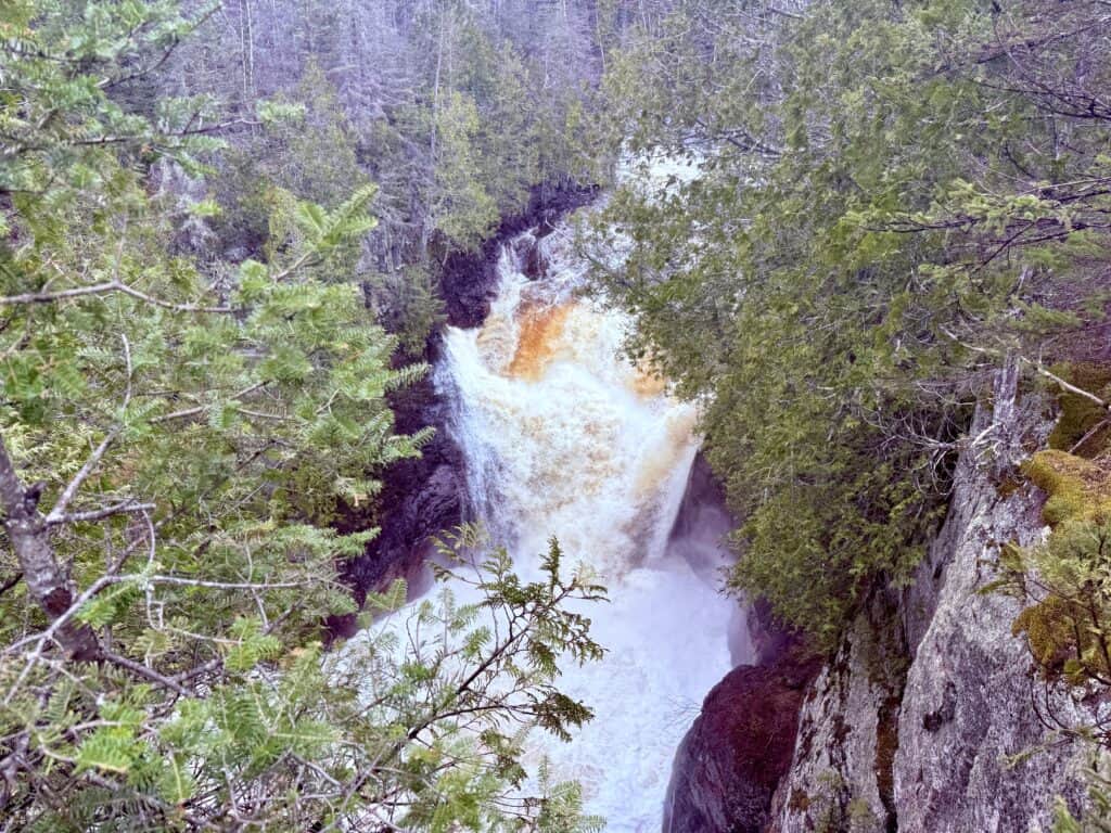 A long, wide, and powerful spring waterfall.  The deep hole on the left is somewhat visible.