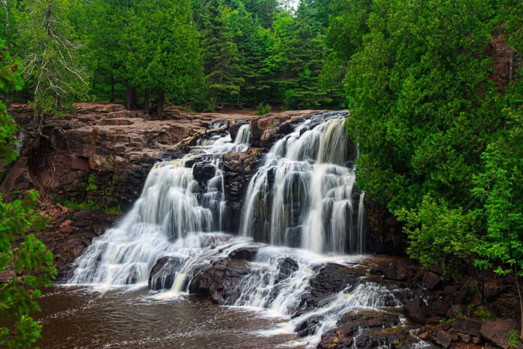 The expansive Upper Falls, surrounded by bursts of green from the surrounding trees. 