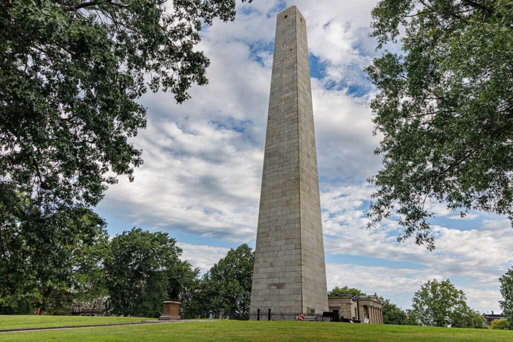 Bunker Hill Obelisk soars into the sky.  People standing next to it look tiny.