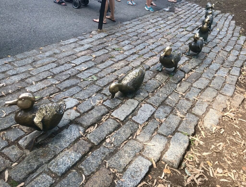 Bronze Make Way for Ducklings statues with the mom in front and the babies following behind